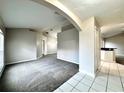 Spacious living room with carpet flooring and white tiled floors leading to bar-style kitchen area at 468 Rio Grande Ct, Kissimmee, FL 34759