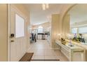 Inviting foyer with tiled floor, decorative mirror, and view into the adjacent kitchen at 4700 Prairie Point Blvd, Kissimmee, FL 34746