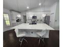Modern kitchen featuring a spacious island with quartz countertops, white cabinets, and stainless steel appliances at 4760 Ohio Ave, Sanford, FL 32771