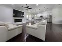 Open-concept living room with a modern fireplace, sleek furniture, and seamless flow to the updated kitchen at 4760 Ohio Ave, Sanford, FL 32771