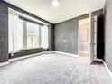 Bright, carpeted bedroom with a large window offering plenty of natural light and textured wall at 4993 Southlawn Ave, Orlando, FL 32811