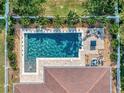 Aerial view of a backyard pool and patio area with a well-maintained lawn and landscaping at 5018 Tupelo Ct, Minneola, FL 34715