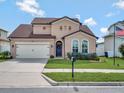 Beautiful two-story home with a well manicured lawn, attached garage, and a blue front door at 5018 Tupelo Ct, Minneola, FL 34715