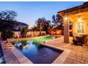 Backyard pool area featuring brick pavers, tropical landscaping, lighting and a comfortable patio set at 5018 Tupelo Ct, Minneola, FL 34715