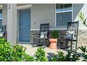 Comfortable front porch featuring stone accents, rocking chairs, and stylish décor creating a cozy outdoor space at 5630 Stockade Blvd, St Cloud, FL 34771
