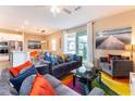 Bright living room with modern furniture, colorful decor and a sliding glass door to the outdoor patio at 7951 Haverhill Way, Kissimmee, FL 34747