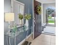 Inviting entryway featuring a glass console table, decorative mirror, and stylish decor with ample natural light at 8615 N Rindge Rd, Polk City, FL 33868