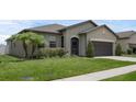 Beautiful home with a lush green lawn, well-kept landscaping, and a convenient two-car garage at 8615 N Rindge Rd, Polk City, FL 33868
