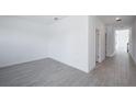 A bright bedroom with light gray wood-look floors, white walls and baseboards, and natural light at 9199 Waverly Walk Dr, Orlando, FL 32817