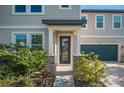 Inviting front entrance with stone accents, a covered porch, and a well-maintained lawn at 9199 Waverly Walk Dr, Orlando, FL 32817
