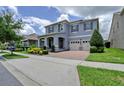 Charming two-story home featuring a brick driveway, three-car garage, manicured landscaping, and a welcoming front porch at 9422 Jaywood Rd, Winter Garden, FL 34787