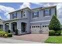 Beautiful two-story home with a three-car garage, stone accents, a welcoming front porch, and manicured landscaping at 9422 Jaywood Rd, Winter Garden, FL 34787
