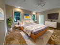 Serene bedroom featuring a king-sized bed, plush carpet, modern decor, and ample natural light at 10170 Se 106Th Ln, Belleview, FL 34420