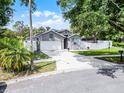 Gray single-Gathering home on a spacious lot, featuring a two-car garage and fenced yard at 1020 Taproot Dr, Winter Springs, FL 32708