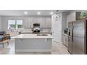 Modern kitchen with gray cabinets, stainless steel appliances, and a spacious center island at 1020 Taproot Dr, Winter Springs, FL 32708