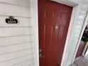 Close-up of a red front door with a decorative knocker and unit number 1015 at 11568 Westwood Blvd # 1015, Orlando, FL 32821