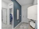 Modern entryway with a blue accent wall, stylish mirror, and neutral tile flooring at 1219 Normandy Dr, Haines City, FL 33844