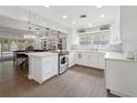 Open kitchen with modern appliances, island, white cabinets, and seamless flow to living area at 1770 Chinook Trl, Maitland, FL 32751