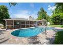 Sparkling in-ground pool with brick paver deck, screened in lanai, and lush tropical landscaping at 1770 Chinook Trl, Maitland, FL 32751