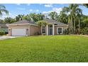 Beautiful home with a well-manicured lawn, a side-entry garage, and mature trees at 1907 Sir Lancelot Cir, St Cloud, FL 34772