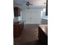 Kitchen featuring dark cabinets, a double-basin sink, and a view to a large double-door pantry at 2103 Mantilla Ave, Orlando, FL 32811