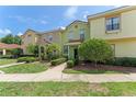 Charming townhome with red tiled roof, mature landscaping, and inviting walkway on a sunny day at 214 Monroe Cir, Davenport, FL 33896