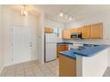 Functional kitchen with breakfast bar and white appliances and tile flooring offers plenty of space at 214 Monroe Cir, Davenport, FL 33896