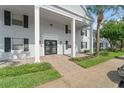 The entrance shows a light gray brick facade with black shutters and double doors. It features fresh landscaping at 225 Lewfield Cir # 225, Winter Park, FL 32792