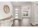Inviting foyer with wood-look floors, a decorative mirror, and a view into the open-concept living area at 2340 Standing Rock Cir, Oakland, FL 34787