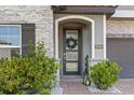 Elegant front door with decorative wreath, stone accents, and charming landscaping at 2340 Standing Rock Cir, Oakland, FL 34787