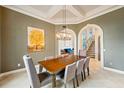 Dining room with a tray ceiling, pendant lighting, and a view into the living space through an arched doorway at 2357 Alaqua Dr, Longwood, FL 32779