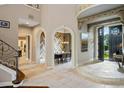 Grand foyer with stone floors, arched doorways and a view into the dining room with wood accent wall at 2357 Alaqua Dr, Longwood, FL 32779
