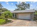 Single-story home with attached two-car garage, well-maintained landscaping, and an expansive driveway for extra parking at 310 E Gulley Ave, Oakland, FL 34760