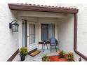Welcoming front porch area with a chair, small table, potted plants, and a 'Welcome' mat at 3336 Gray Fox Cv # 3336, Apopka, FL 32703