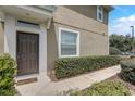 Inviting front entrance with a dark brown door, neutral siding, and manicured hedges at 4178 Sw 43Rd Cir, Ocala, FL 34474