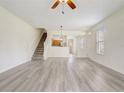 Bright living room with modern wood-look floors, stairs, and open layout to the kitchen at 4178 Sw 43Rd Cir, Ocala, FL 34474
