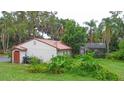 Landscaped backyard with lush greenery, a red tiled roof, and an enclosed pool at 4420 Conway Gardens Rd, Orlando, FL 32806