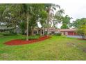 Expansive front yard with a well-manicured lawn and landscaping, showcasing a single-story home with an attached garage at 4420 Conway Gardens Rd, Orlando, FL 32806