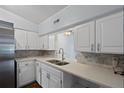 Kitchen featuring white cabinets and quartz countertops with a stainless steel refrigerator at 4420 Conway Gardens Rd, Orlando, FL 32806