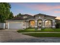 Beautiful home with a well-manicured lawn, covered porch, and a spacious driveway leading to a two-car garage at 701 Little Hampton Ln, Gotha, FL 34734
