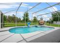 Inviting in-ground screened pool with basketball hoop and outdoor lounge area overlooking the green backyard at 701 Little Hampton Ln, Gotha, FL 34734