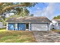The front of the house shows a blue exterior with white trim, and a well-maintained lawn at 7504 Willow Wisp E Dr, Lakeland, FL 33810