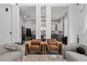 Open-concept living area with modern chairs and view of the kitchen in a modern home at 8131 Vineland Oaks Blvd, Orlando, FL 32835