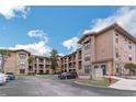 Apartment complex featuring stone accents, balconies, ample parking and nice landscaping at 909 Charo Pkwy # 1011, Davenport, FL 33897