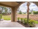 Outdoor patio area featuring stone arch, landscaping, and privacy wall at 909 Charo Pkwy # 1011, Davenport, FL 33897
