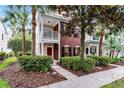 Two story brick townhome featuring a second story porch, landscaped yard, and beautiful curb appeal at 9670 Cypress Pine St, Orlando, FL 32827