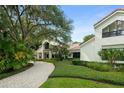 A charming home featuring lush landscaping, a brick driveway, and mature trees at 9743 Chestnut Ridge Dr, Windermere, FL 34786