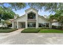 Beautifully landscaped front yard and brick driveway leading to a modern two-story home with large windows at 9743 Chestnut Ridge Dr, Windermere, FL 34786