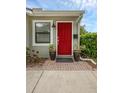 Close-up of the red front door with potted plants and brick walkway adding a touch of elegance at 1021 N Forest Ave, Orlando, FL 32803