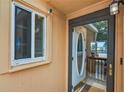 A home's front door with glass, framed by a white doorframe and window with security camera at 1051 S Highland St # 5E, Mount Dora, FL 32757